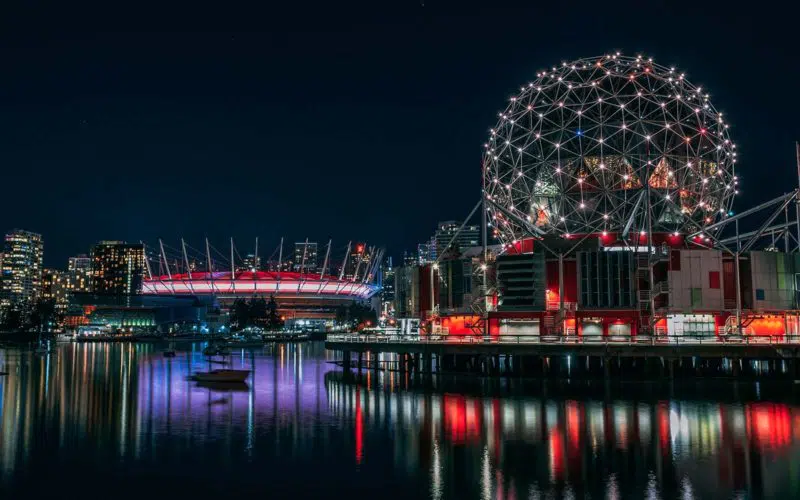 A vibrant night scene with Science World and BC Place Stadium in Vancouver, representing Coevolve's global service delivery capability and technological innovation, as highlighted in the news article about their milestone of offering services in 80 countries
